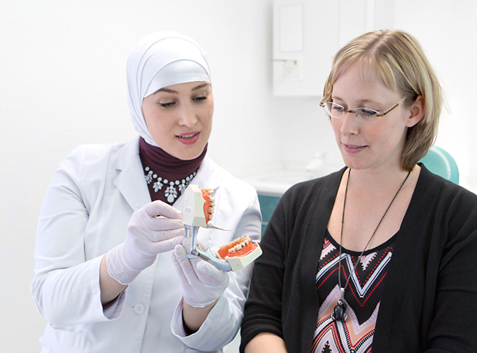 Zahnärztin Luma berät Ihre Patientin über Behandlungsmöglichkeiten.